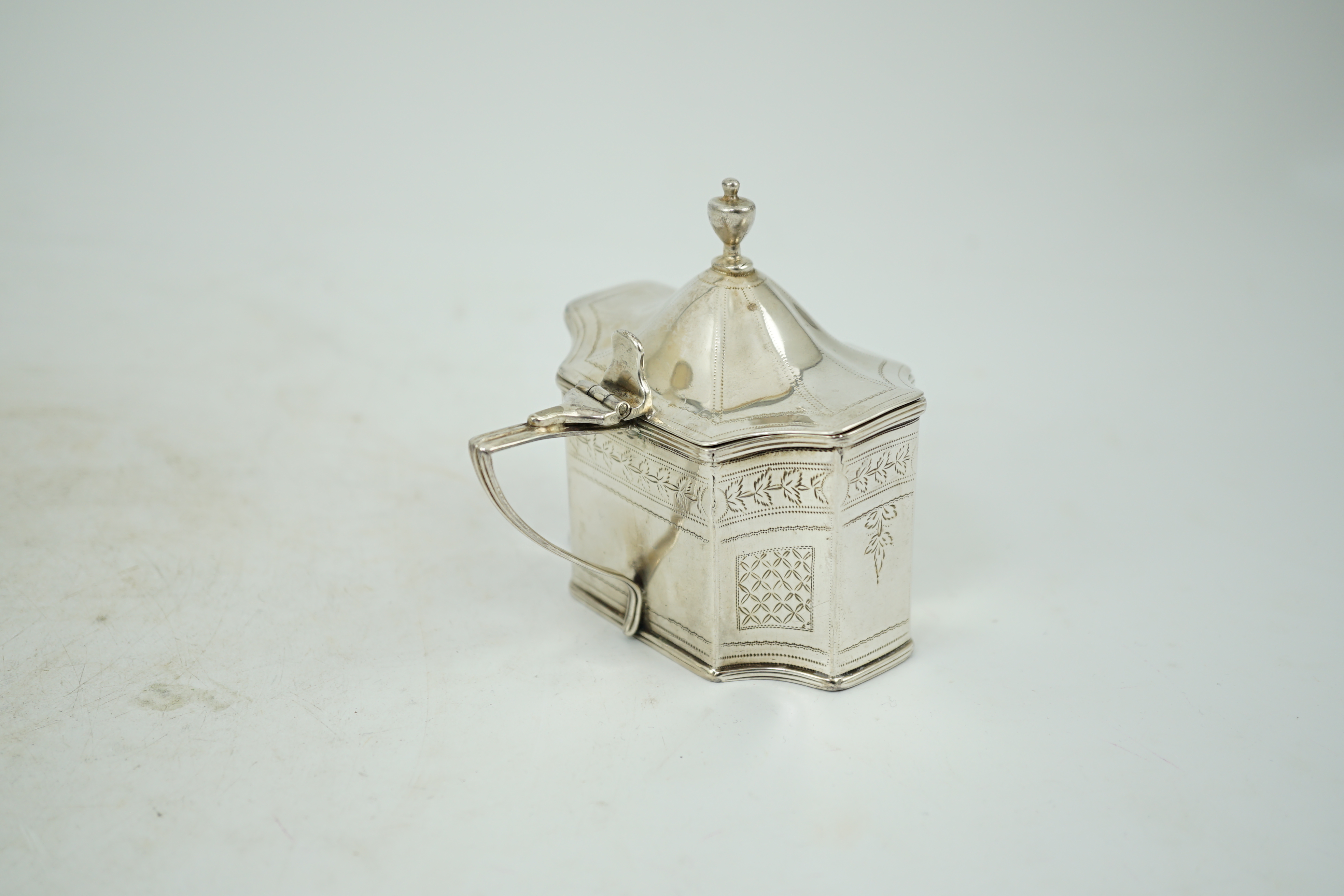 A George III silver mustard pot, with inverted angles and blue glass liner, Alexander Field, London, 1803, height 85mm.